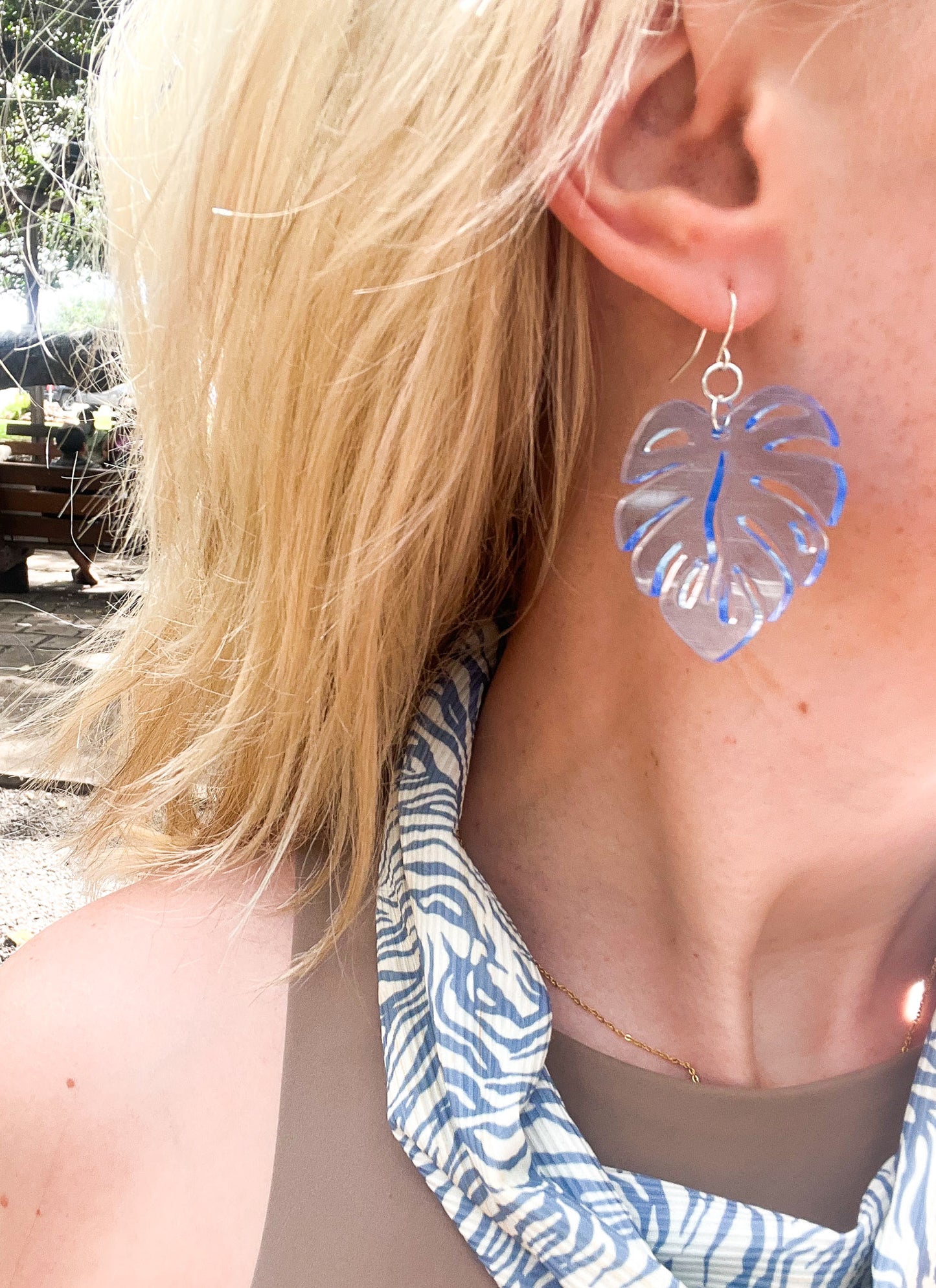 Blue Acrylic Earrings in the shape of a Monstera leaf. Approximately 1.5" x 1.6"