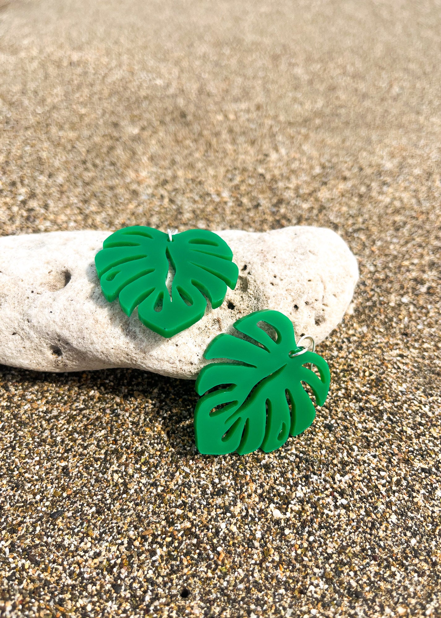 Green Acrylic Earrings in the shape of a Monstera leaf. Approximately 1.5" x 1.6"