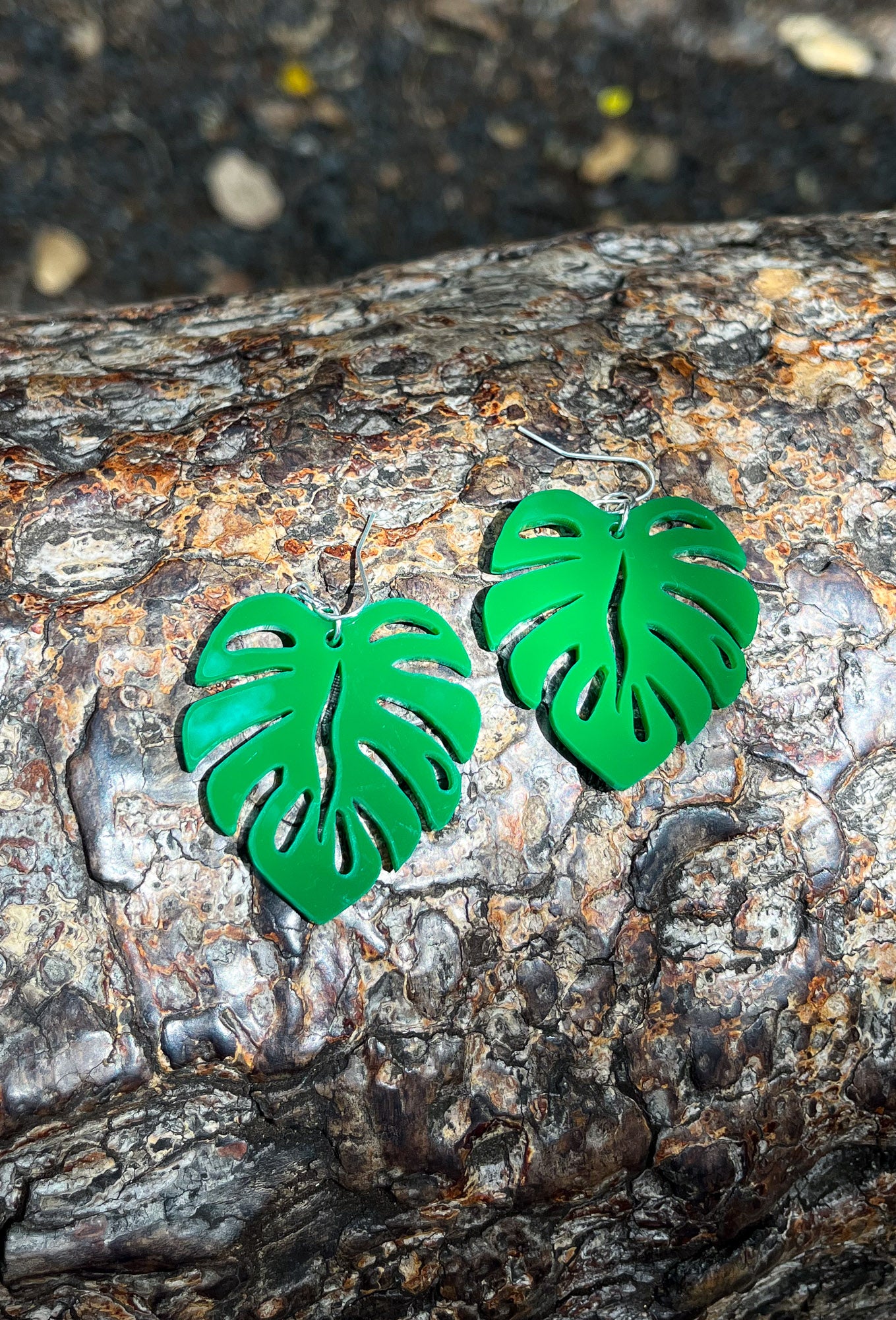 Green Acrylic Earrings in the shape of a Monstera leaf. Approximately 1.5" x 1.6"