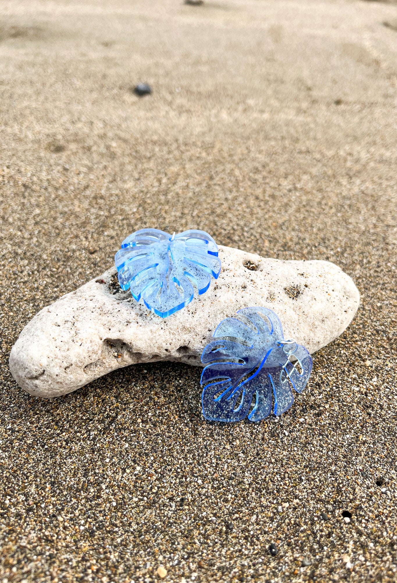 Blue Acrylic Earrings in the shape of a Monstera leaf. Approximately 1.5" x 1.6"