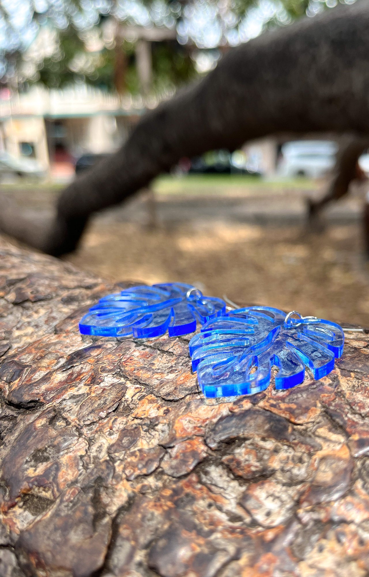 Blue Acrylic Earrings in the shape of a Monstera leaf. Approximately 1.5" x 1.6"