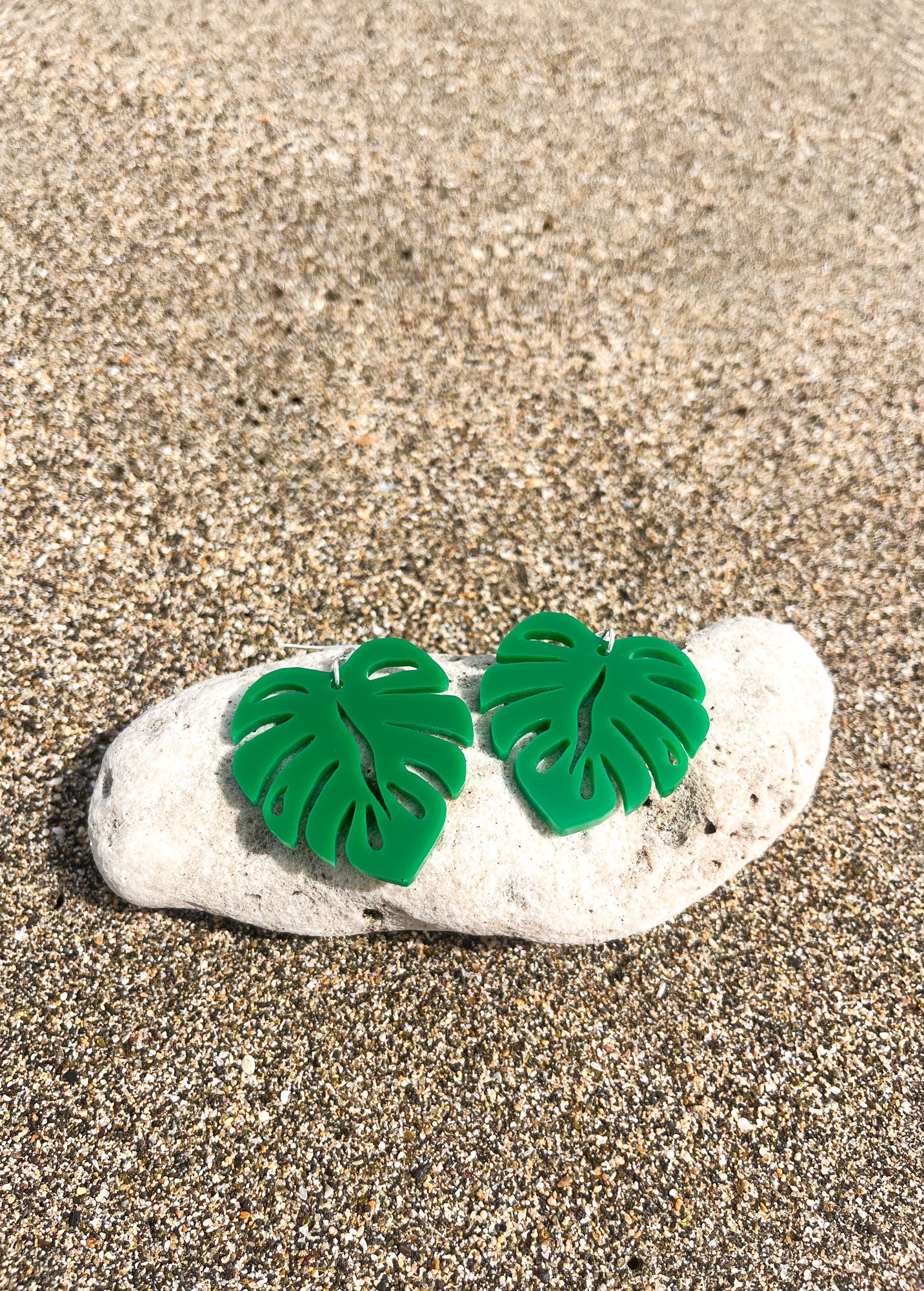 Green Acrylic Earrings in the shape of a Monstera leaf. Approximately 1.5" x 1.6"