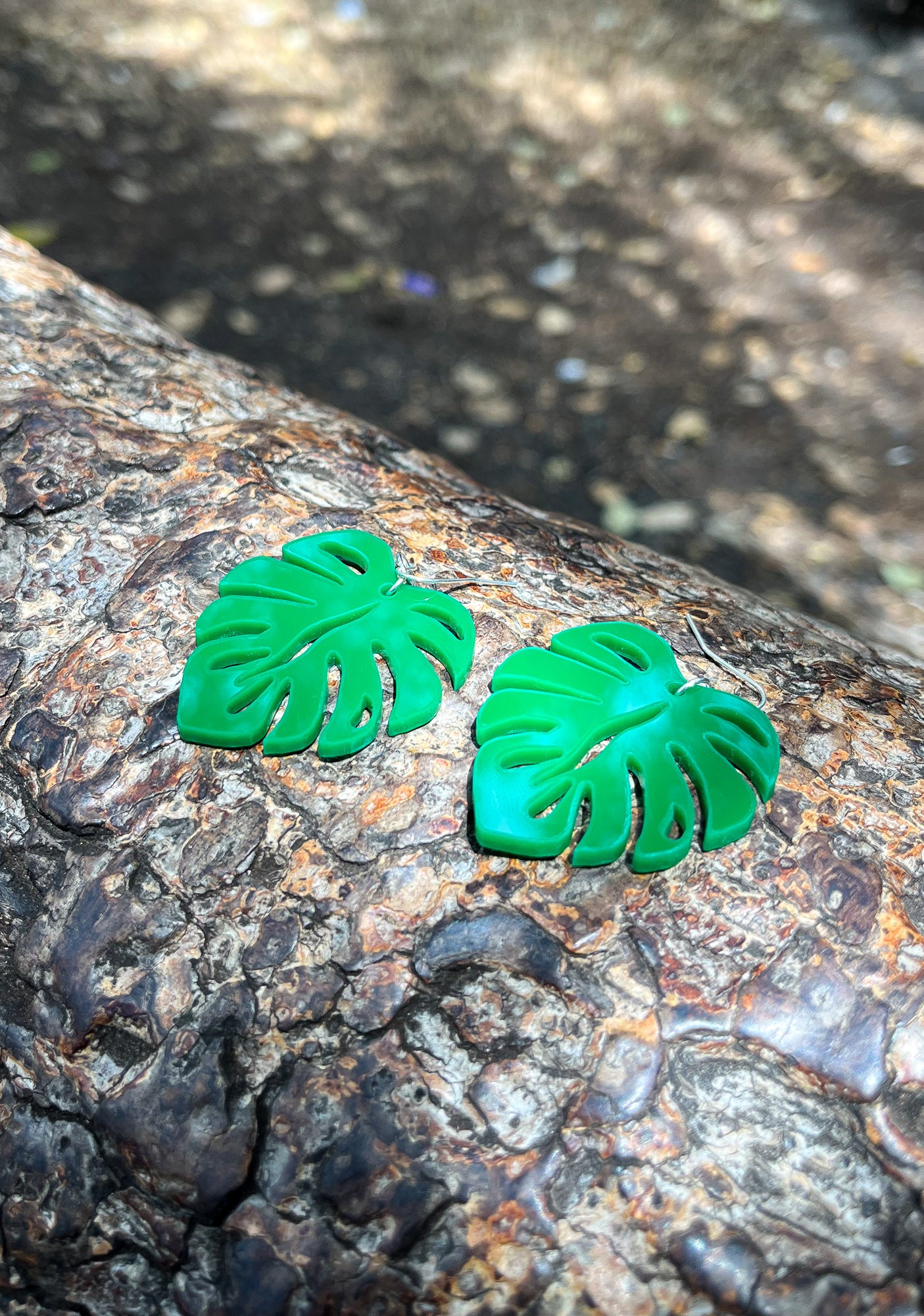 Green Acrylic Earrings in the shape of a Monstera leaf. Approximately 1.5" x 1.6"